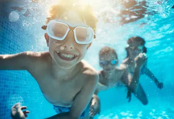 Kids swimming and smiling underwater 