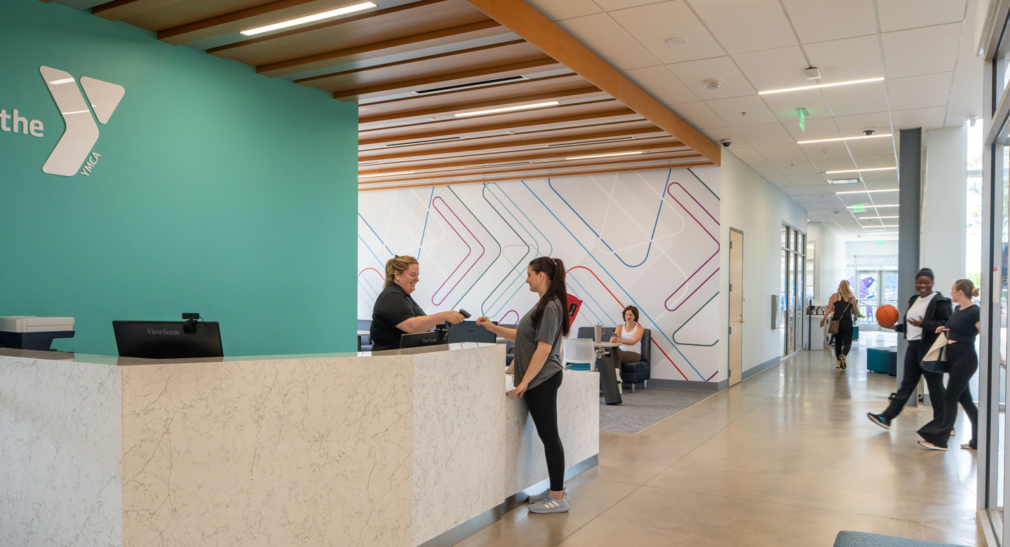Staff member helping someone check in at the welcome desk