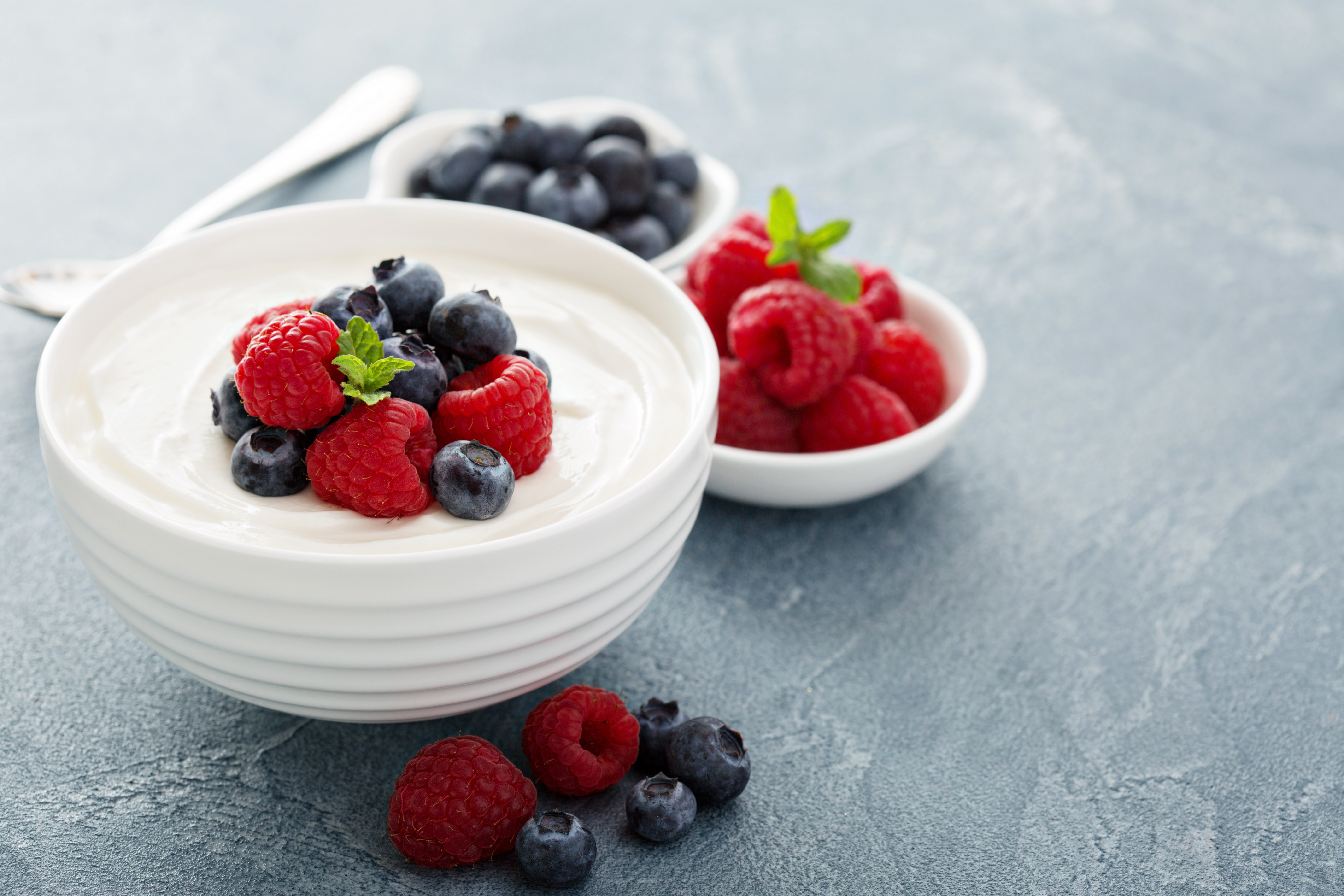 Strawberries and blueberries on top of a bowl of Greek yogurt