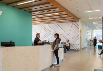 Staff member helping someone check in at the welcome desk