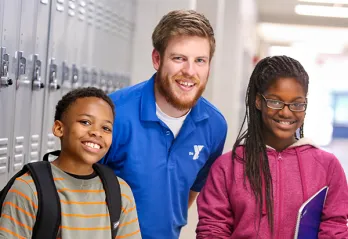Counselor in school hallway talking to two students