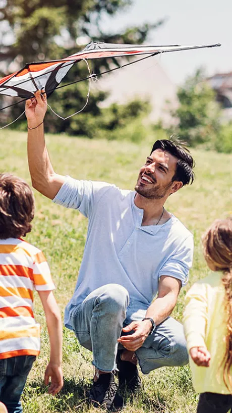 Father with two kids flying a kite