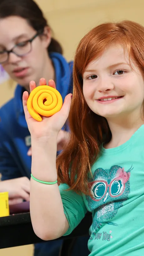 Girl playing with play dough at after school program