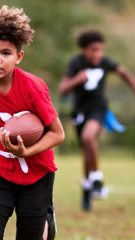 boy running for a touchdown in flag football