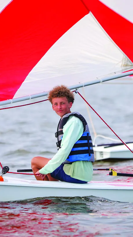 a camper sails a boat at Camp Sea Gull