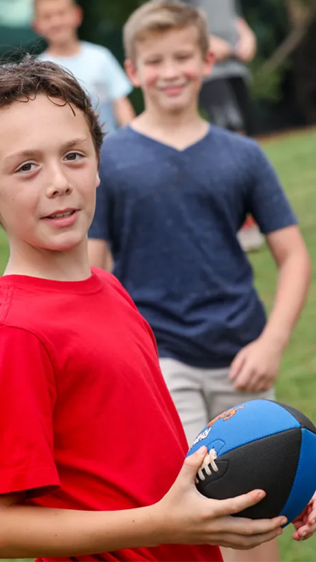 Group of boys playing a game of pickup football after school.
