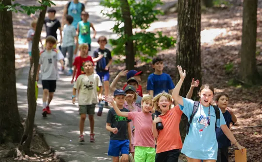 group of kids walking on a trail at day camp
