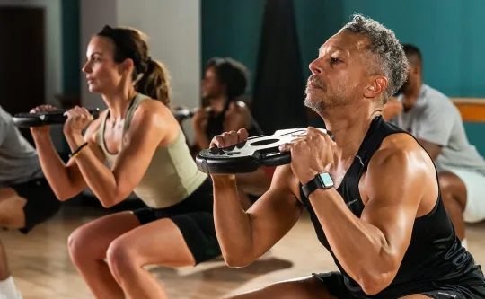 a man uses a plate in a ymca strength class