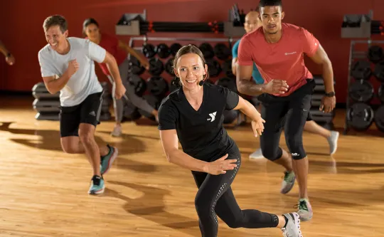 a smiling YMCA instructor leads a Dance class