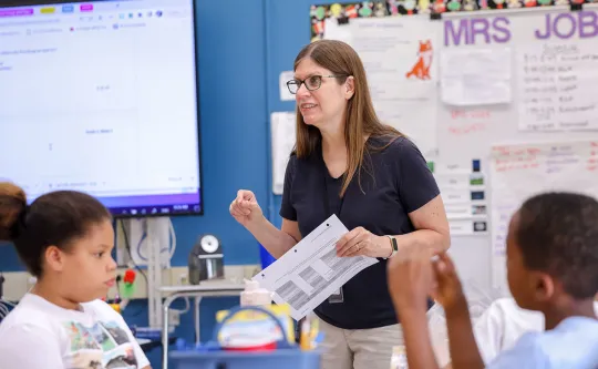 Teacher helping a child with reading skills