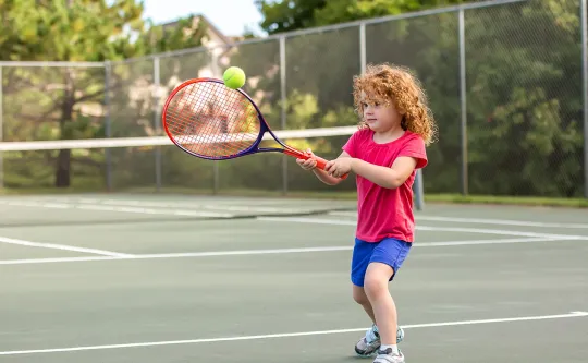 Child playing tennis