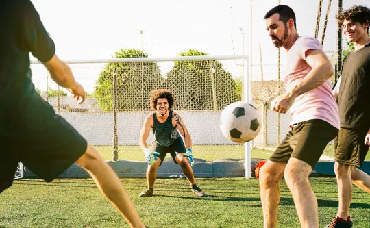 Group of men playing soccer outdoors