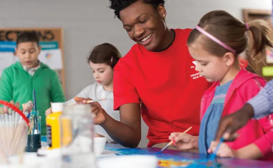 Counselor helping a child with a craft