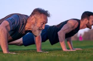Two men doing push ups outside