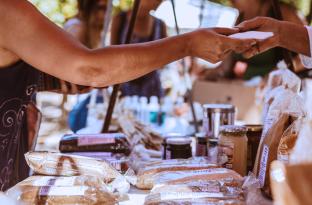 Someone pruchasing homemade bread at a vendor fair