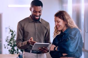 two employees reviewing a file on an ipad