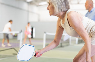woman squatting for Pickleball on courts