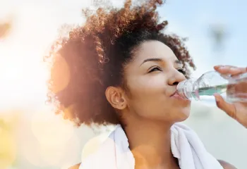 Woman drinking water after outdoor exercise