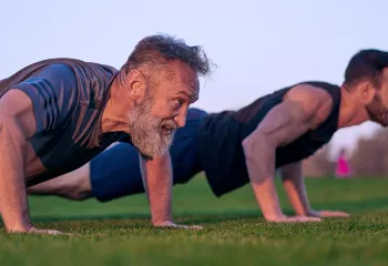 Two men doing push ups outside