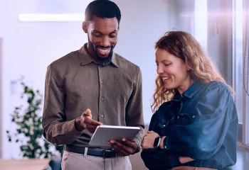 two employees reviewing a file on an ipad