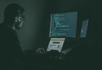 man typing mysteriously in a dark room 