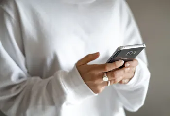 adult holding cell phone in the palm of hand