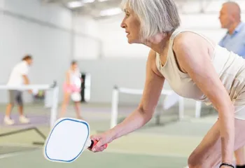 woman squatting for Pickleball on courts