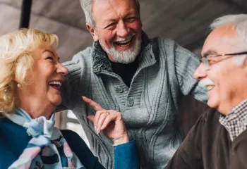Older adults gathering around a table for conversation in a well lit room