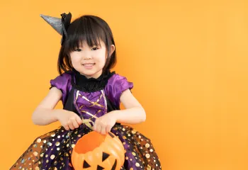 young girl dressed up in a purple and black sparkly costume