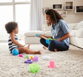 caregiver playing with child on carpet