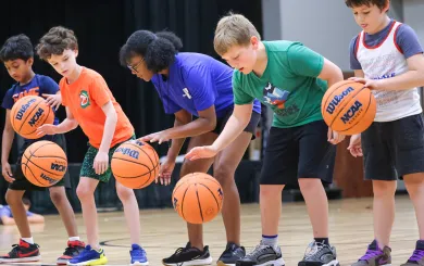 Group of kids learning dribble skills for basketball