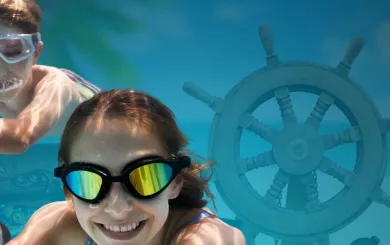 Family swimming with pirate gear around them underwater with goggles