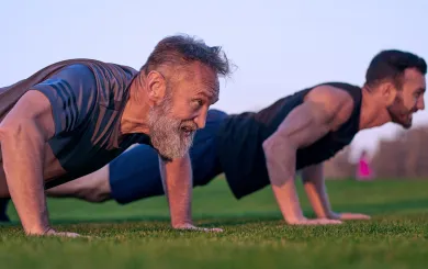 Two men doing push ups outside