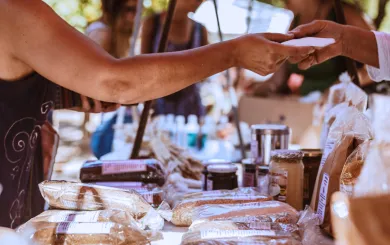 Someone pruchasing homemade bread at a vendor fair
