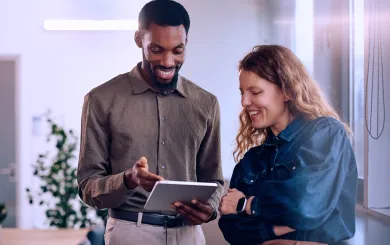 two employees reviewing a file on an ipad