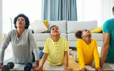 Family doing yoga- like stretches together in a bright airy room