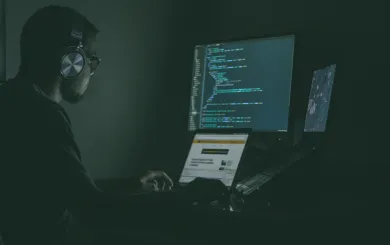 man typing mysteriously in a dark room 