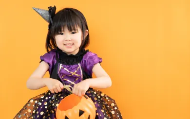 young girl dressed up in a purple and black sparkly costume