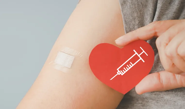 Person holding a heart next to a band aid