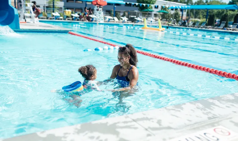 waleska teaches a young girl how to swim