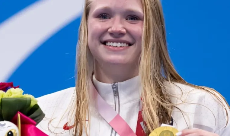 image of smiling hannah aspden with her Paralympic gold medal in Tokyo