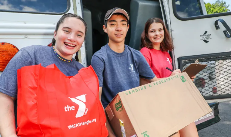 group of smiling teenagers collecting items for donation 