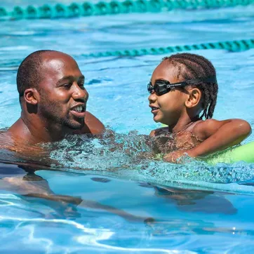 Young boy swimming with YMCA instructor