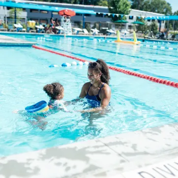 waleska teaches a young girl how to swim