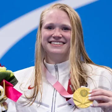 image of smiling hannah aspden with her Paralympic gold medal in Tokyo