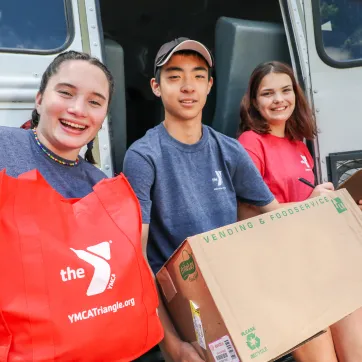 group of smiling teenagers collecting items for donation 