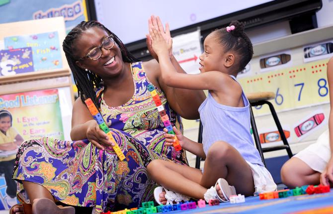 Teacher helping a young child with math skills