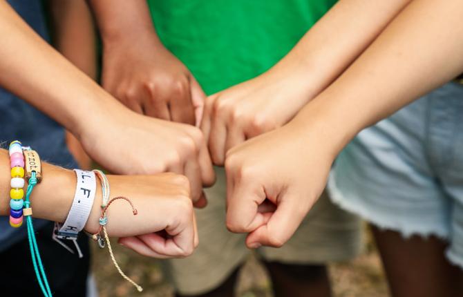 Teens together with hands in a huddle