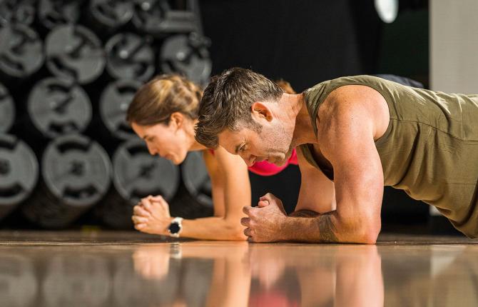 Two people plank during a YMCA fitness class