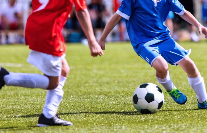 Soccer players moving the ball on the field